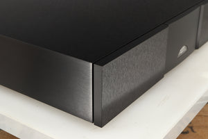 Front left corner of a used Naim CD555PS DR Power Supply in a black finish