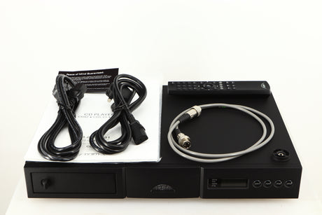 Top of a used Naim CD5si CD Player in a black finish showing Mains Cable, Schuko Cable, CD Puck, SNAIC5, Remote and Manual