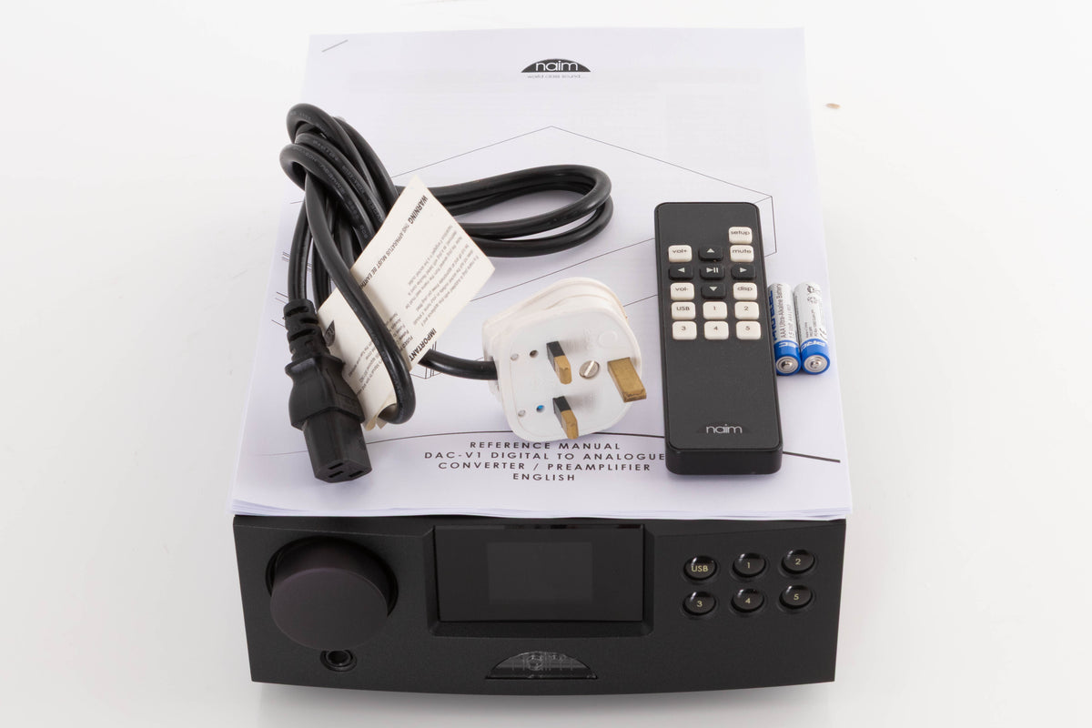 Top of a used Naim DAC V-1 Digital Analogue Converter in a Black finish showing Mains Cable, Remote, Batteries and Manual 