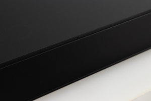 Close up of a used Naim Flatcap 2X Power Supply in a black finish showing some scratching on left side