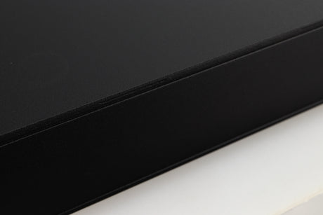 Close up of a used Naim Flatcap 2X Power Supply in a black finish showing some scratching on left side