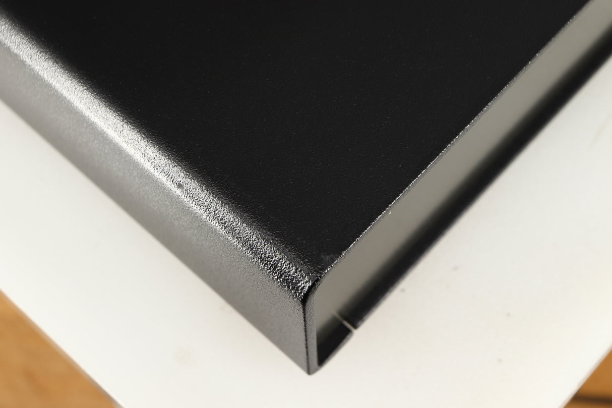 Close up of a used Naim Flatcap Power Supply in a black finish showing small graze on front edge and left side