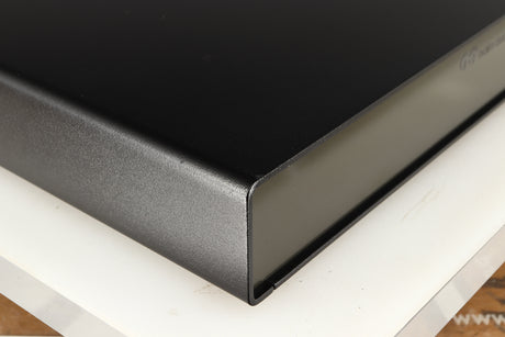 Front left corner of a used Naim Flatcap Power Supply in a black finish