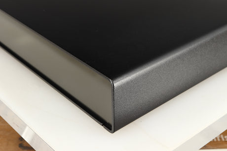 Front right corner of a used Naim Flatcap Power Supply in a black finish