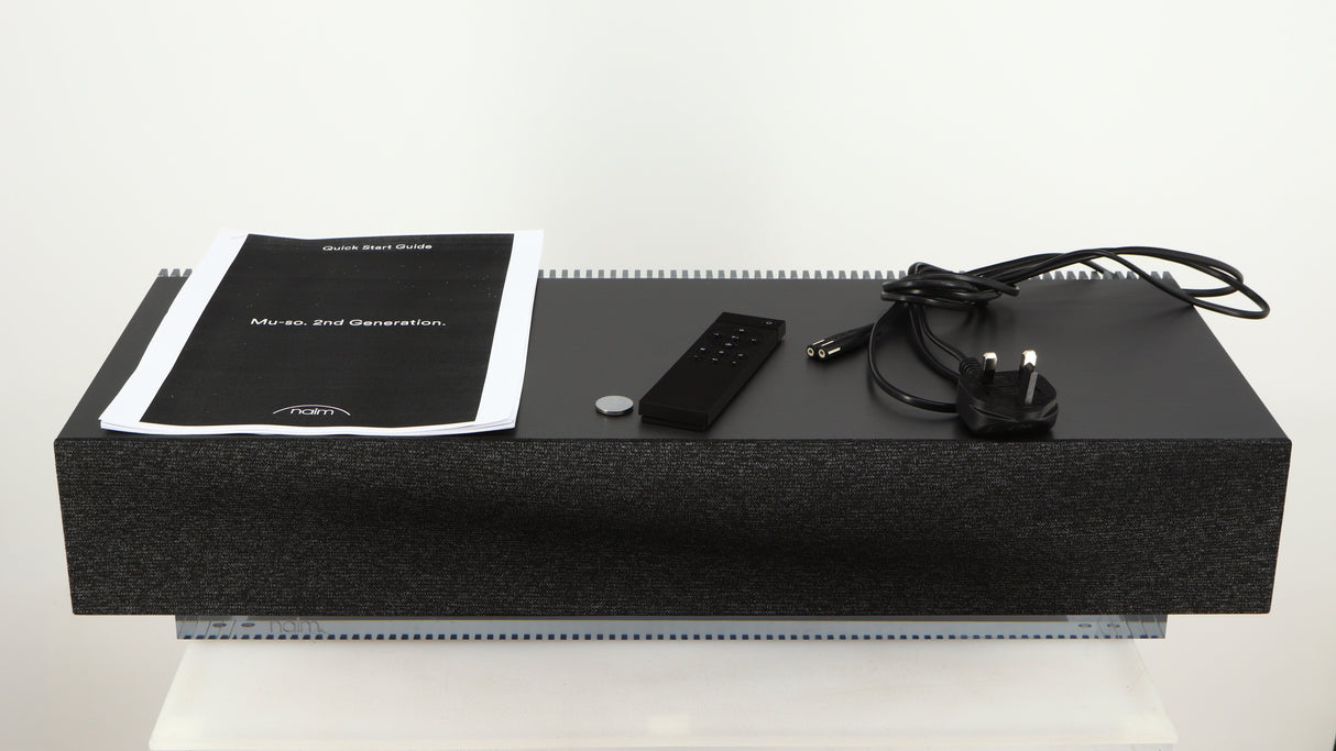 Top of a used Naim Mu-so GEN2 Wireless Music System in a silver finish showing Manual, Battery, Remote and Power Cable