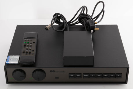 Top of a used Naim NAC102 W/ NAPSC in a Black finish showing Remote and Batteries