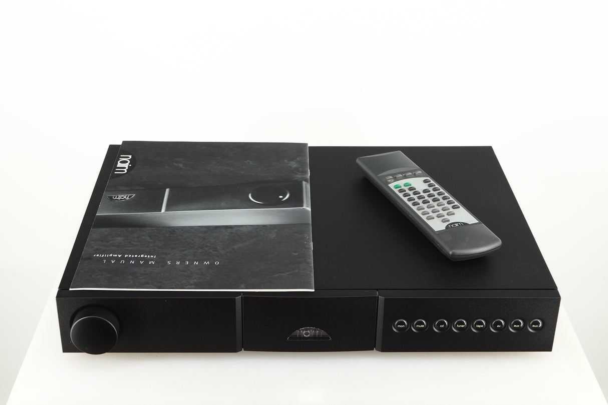 Top of a used Naim NAIT 5 Integrated Amplifier in a black finish showing a manual and remote