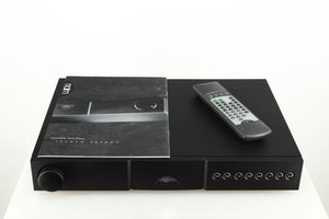 Top of a used Naim NAIT 5 Integrated Amplifier in a black finish showing a manual and remote