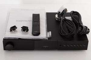 Top of a used Naim Nait XS-2 Integrated Amplifier in a Black finish showing Remote, Batteries, Manual, Link Plugs, Mains Cable and Schuko Cable