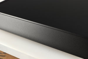Close up of a used Naim Nait XS-2 Integrated Amplifier in a black finish showing small nick and light scratch on right side