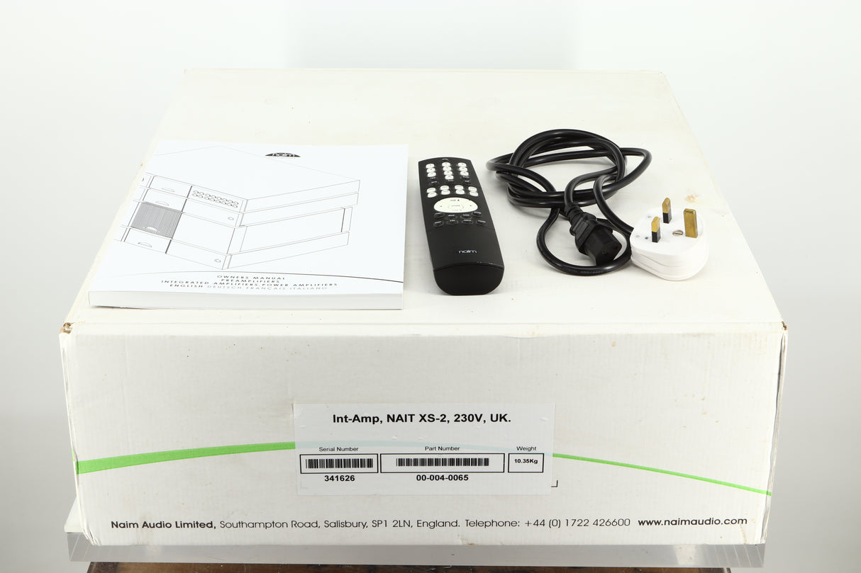 Box of a used Naim Nait XS-2 Integrated Amplifier showing mains cable, manual, and remote