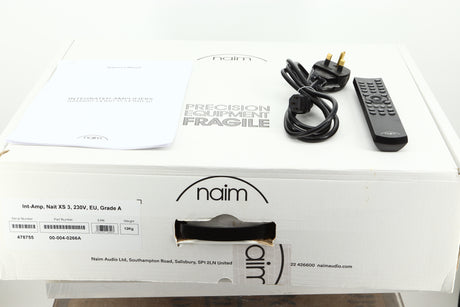 Box of a used Naim Nait XS-3 Integrated Amplifier showing mains cable, and remote