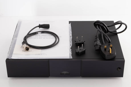 Top of a used Naim NAP250 DR Power Amplifier in a Black finish showing Manual, SNAIC4, Mains Cable and Link Plugs