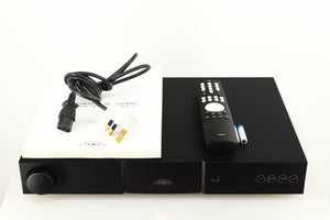Top of a used Naim Nait 5si Integrated Amplifier in a black finish showing Manual, Mains Cable, Remote and 2x Batteries