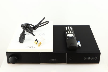 Top of a used Naim Nait 5si Integrated Amplifier in a black finish showing Manual, Mains Cable, Remote and 2x Batteries