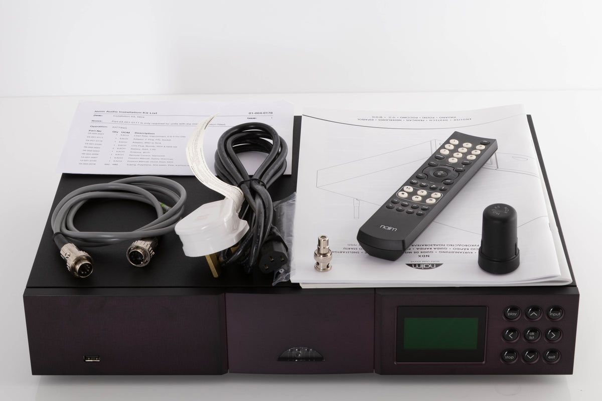 Top of a used Naim NDX Network Streamer in a Black finish showing Manual, Remote, Batteries, Mains Cable, BNC Adaptor, Link Plug, Wi-Fi Antenna and SNAIC5