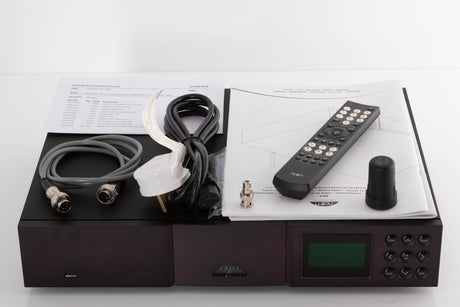 Top of a used Naim NDX Network Streamer in a Black finish showing Manual, Remote, Batteries, Mains Cable, BNC Adaptor, Link Plug, Wi-Fi Antenna and SNAIC5