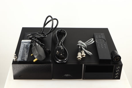 Top of a used Naim NDX2 Network Streamer in a black finish showing Manual, Remote, Batteries, Mains Cable, Schuko Cable, SNAIC5, Link Plug, BNC Adaptor, Bluetooth Antenna and Wi-Fi Antenna