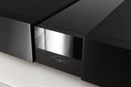 Close up of a used Naim NPX300 Power Supply in a black finish showing scratching on logo