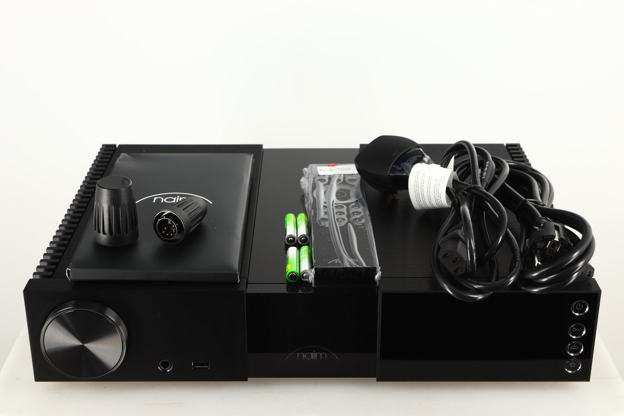 Top of a used Naim NSC 222 Streaming Pre Amplifier in a black finish showing Manual, Remote, Batteries, Link Plugs, Mains Cable and Schuko Cable