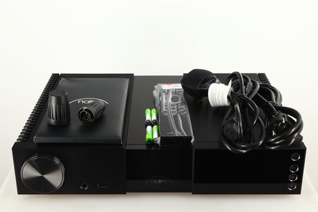 Top of a used Naim NSC 222 Streaming Pre Amplifier in a black finish showing Manual, Remote, Batteries, Link Plugs, Mains Cable and Schuko Cable