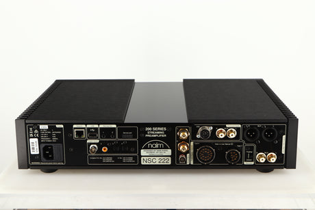 Rear view of a used Naim NSC 222 Streaming Pre Amplifier in a black finish showing Mains Input, USB Input, Network Input, Optical Inputs, Phono Inputs, Phono Outputs, DIN Input and XLR Outputs
