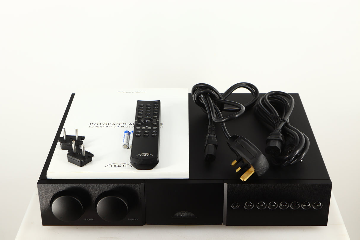 Top of a used Naim Supernait 3 Integrated Amplifier in a black finish showing Manual, Remote, Batteries, Mains Cable, Schuko Cable and Link Plugs
