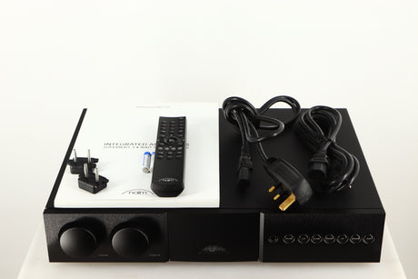 Top of a used Naim Supernait 3 Integrated Amplifier in a black finish showing Manual, Remote, Batteries, Mains Cable, Schuko Cable and Link Plugs