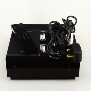 Top of a used Naim Uniti Atom Headphone Edition Streaming Amplifier in a black finish showing Remote, 4x Batteries, Schuko Cable, mains Cable and Manual