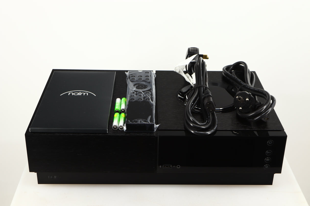 Top of a Naim Uniti Nova Power Edition Streaming System in a black finish showing Manual, Remote, 4x Batteries, Mains Cable and Schuko Cable