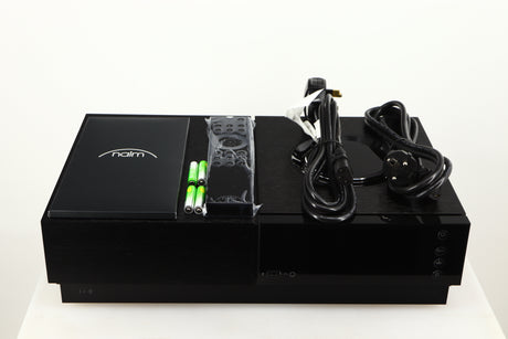 Top of a Naim Uniti Nova Power Edition Streaming System in a black finish showing Manual, Remote, 4x Batteries, Mains Cable and Schuko Cable