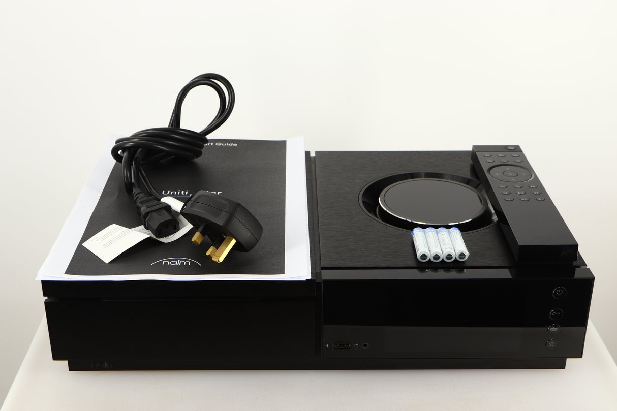 Top of a used Naim Uniti Star Integrated Music System in a black finish showing Manual, Mains Cable, Batteries and Remote