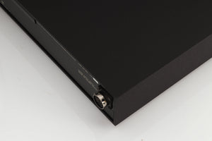 Rear left corner of a used Naim XPS Power Supply in a black finish