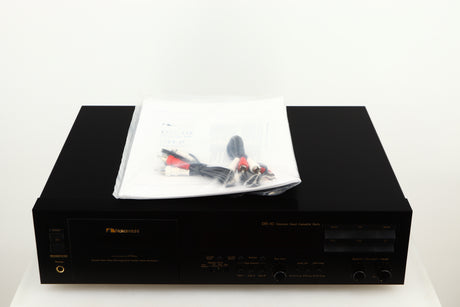 Top of a used Nakamichi DR-10 Cassette Deck in a black finish showing Manual and 2x Interconnect Cables