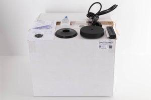 Box for a used Okki Nokki One Record Cleaning Machine in a Black finish showing Manual, Mains Cable, Cleaning Fluid, Brush and Spare Logo
