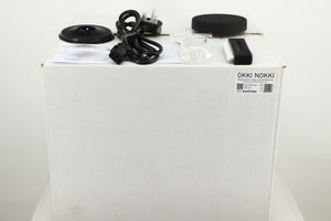 Box for a used Okki Nokki One Record Cleaning Machine in a black finish showing Mains Cable, Brush, Cleaning Fluid, Logo and Manual