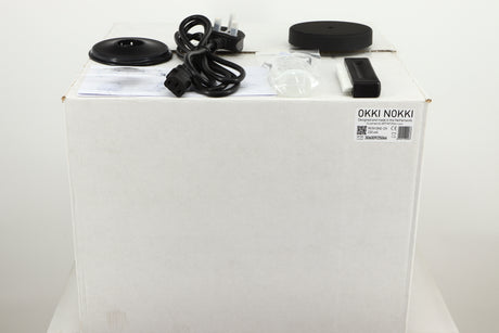 Box for a used Okki Nokki One Record Cleaning Machine in a black finish showing Mains Cable, Brush, Cleaning Fluid, Logo and Manual