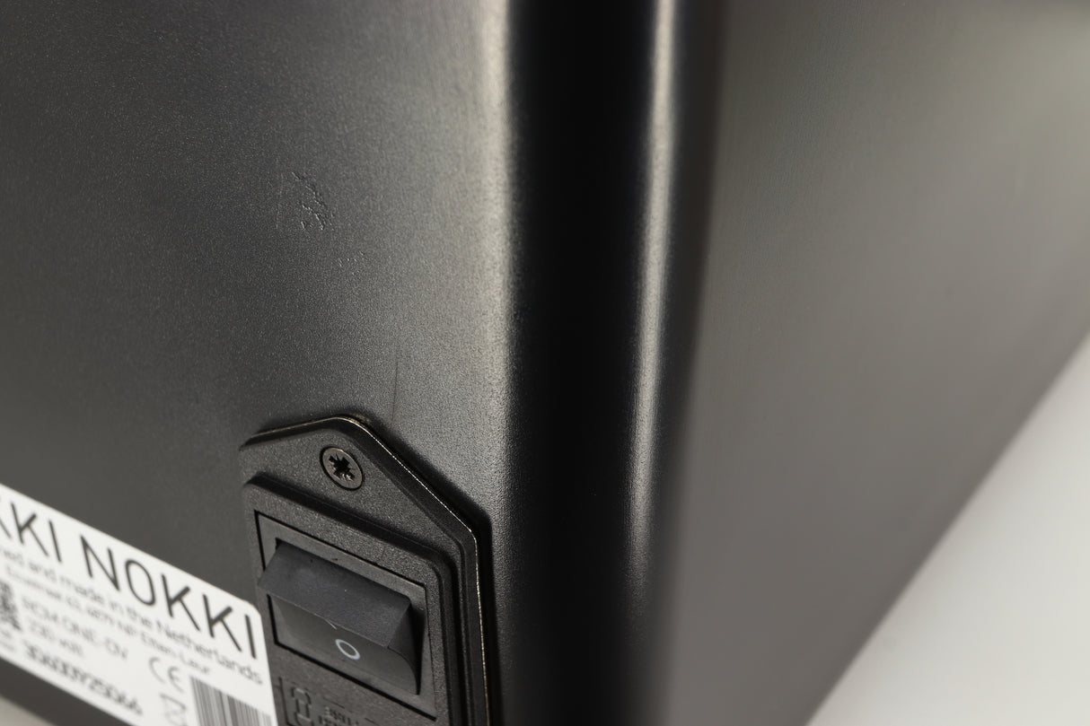Close up of a used Okki Nokki One Record Cleaning Machine in a black finish showing crack on near mains input