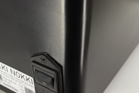 Close up of a used Okki Nokki One Record Cleaning Machine in a black finish showing crack on near mains input