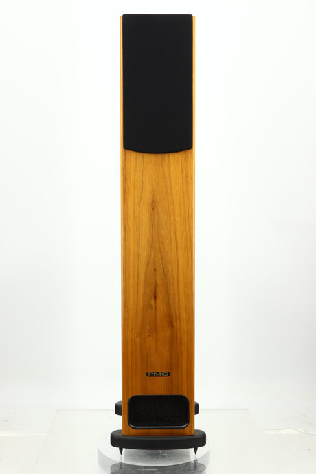 Front view of a PMC GB1 Floorstanding Speaker in a oak finish showing a grille
