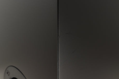 Close up of a used PMC Prodigy 1 Standmount Speakers in a black finish showing some scratching