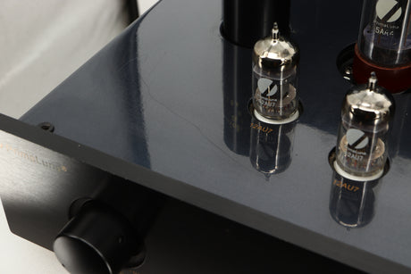 Close up view of a used PrimaLuna Prologue Premium Pre Amplifier in Black finish showing some scratching on the top surface