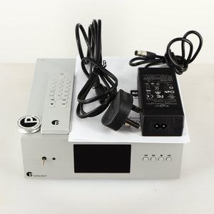 Top of a used Project CD Box RS2 T CD Transport in a silver finish showing PSU, Power Cable, Manual, Remote and Clamp