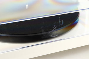 Close up of a used Project Debut Carbon Turntable / Ortofon 2M Blue Cartridge in a white finish showing some scratching on lid