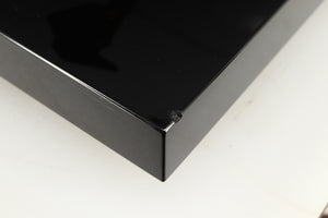 Close up of a used Project Debut Carbon Turntable in a piano black finish showing chip on front right corner
