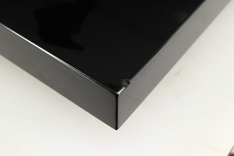 Close up of a used Project Debut Carbon Turntable in a piano black finish showing chip on front right corner