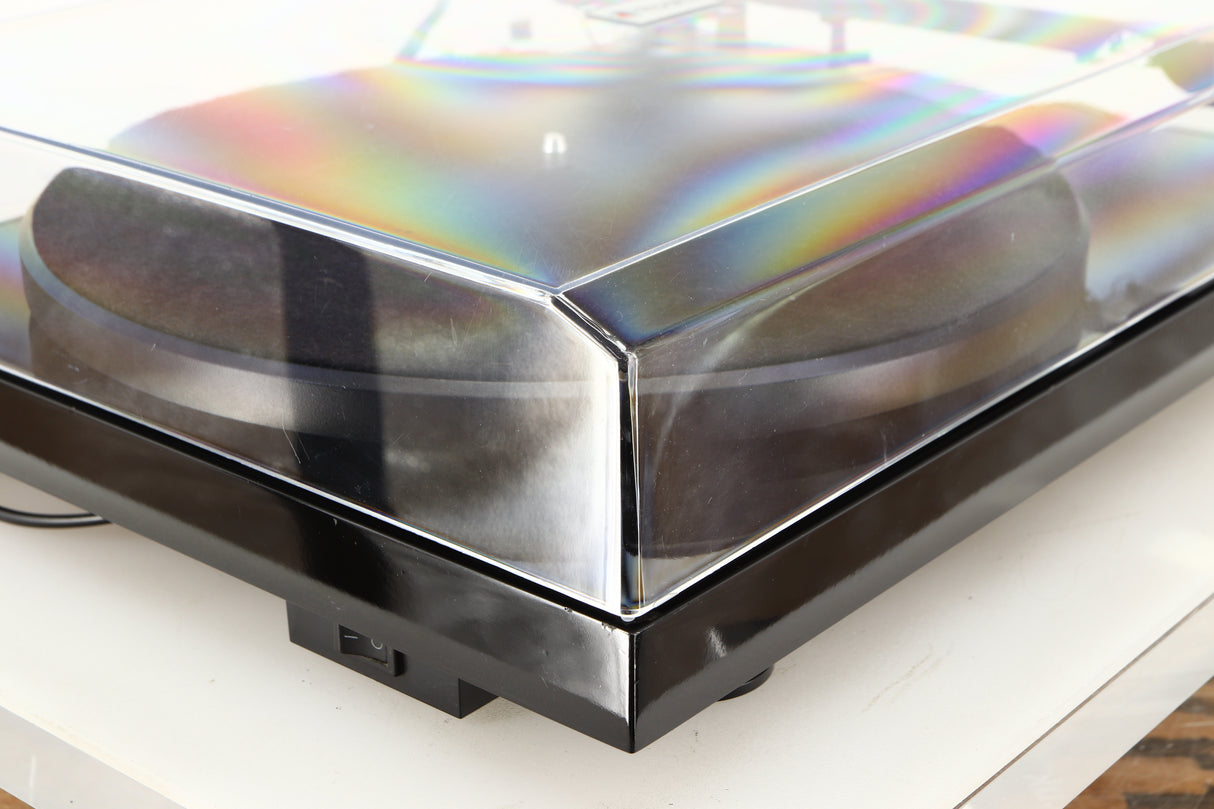 Front left corner of a used Project Debut Carbon Turntable in a piano black finish