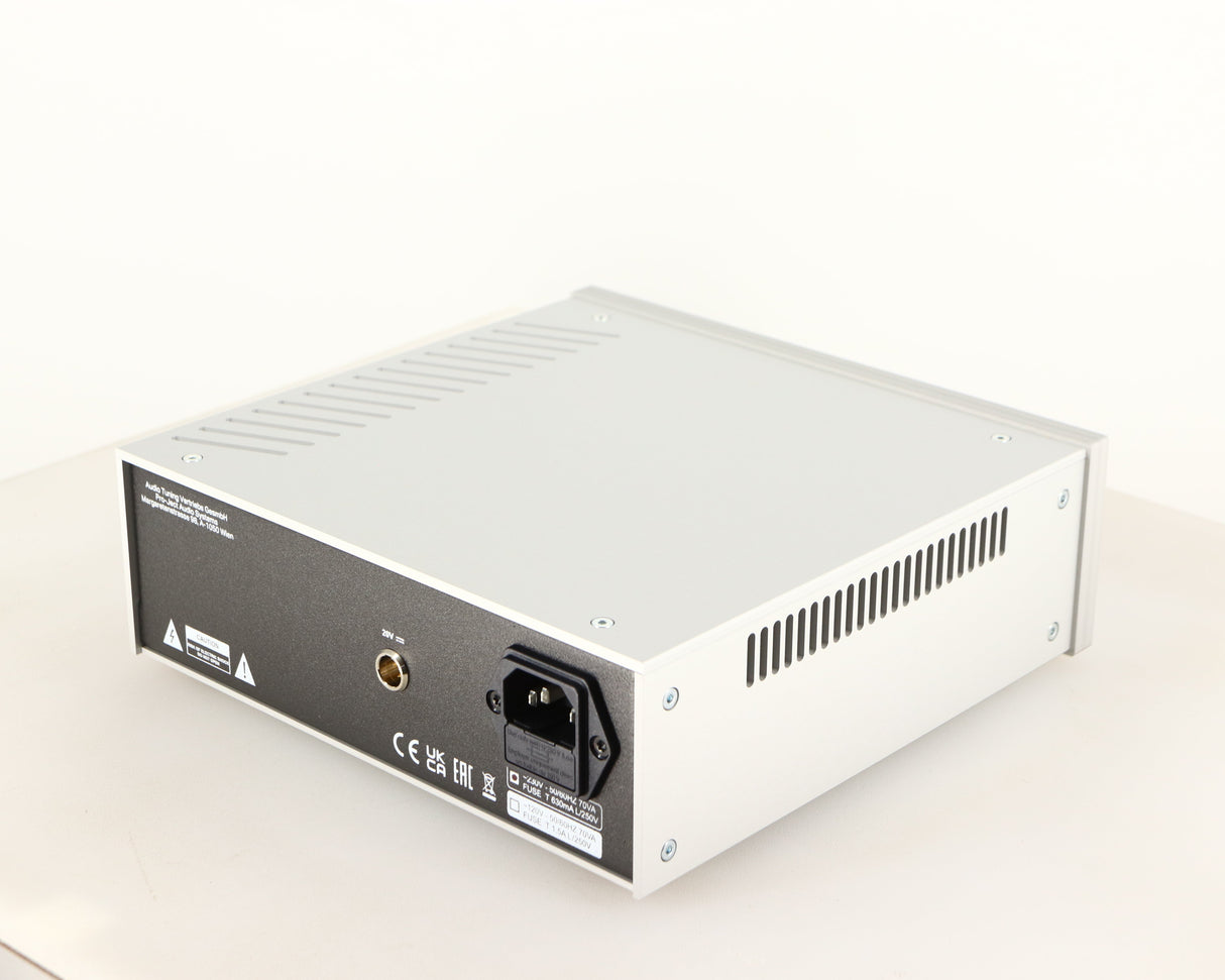 Rear left corner of a used Project Power Box RS Uni-1-Way Power Supply in a silver finish