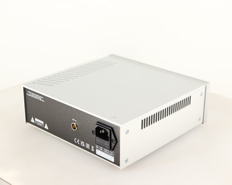 Rear left corner of a used Project Power Box RS Uni-1-Way Power Supply in a silver finish