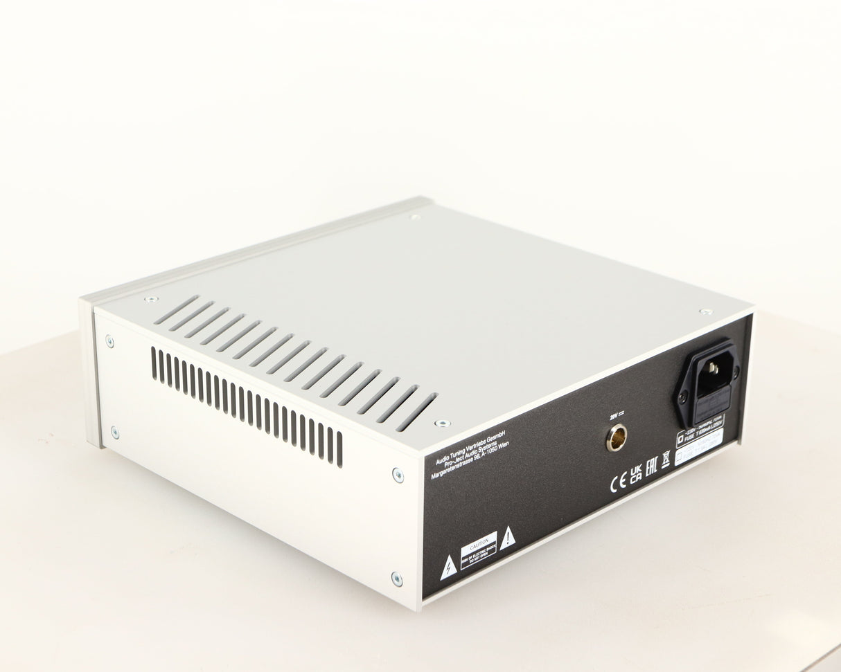 Rear right corner of a used Project Power Box RS Uni-1-Way Power Supply in a silver finish